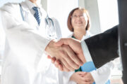 Doctor shaking hand with person in suit