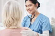 Nurse wearing stethoscope talking to patient